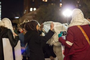 Teilnehmerinnen der Kundgebung am Washington Square Park binden sich ihre Schals wie Hijabs um — aus Solidarität (c) Anna Goldenberg